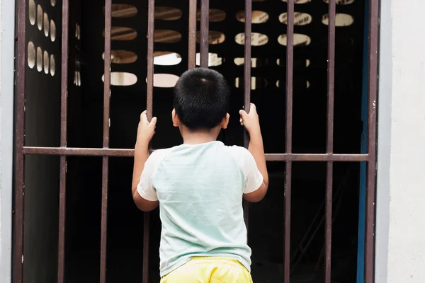Маленький мальчик сидит в тюрьме — стоковое фото