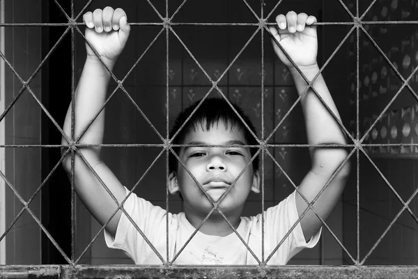 Αγόρι λυπημένος στέκεται μόνη της πίσω από την φυλακή, μαύρο και άσπρο τόνος — Φωτογραφία Αρχείου