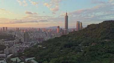 Dağlar ve günbatımı bulutlarıyla şehir silueti. Taipei, Tayvan