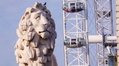 South Bank Lion Westminster Köprüsü 'nde, arka planda Londra gözü var..