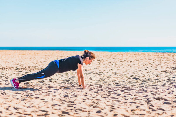 Middle aged woman doing exercise on the beach