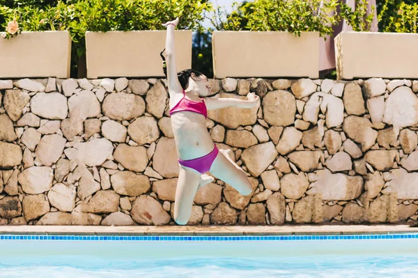 Little child jumping into a pool