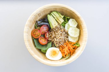 Havuç, yumurta, salatalık, avokado, domates ve kuzu marullu esmer pirinç salatası. Üst görünüm.