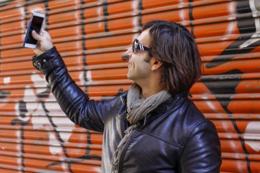 Güneş gözlüğü telefonunu arayan adam