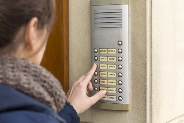 Femme appelant sur l'interphone et appuyant sur le bouton — Photo