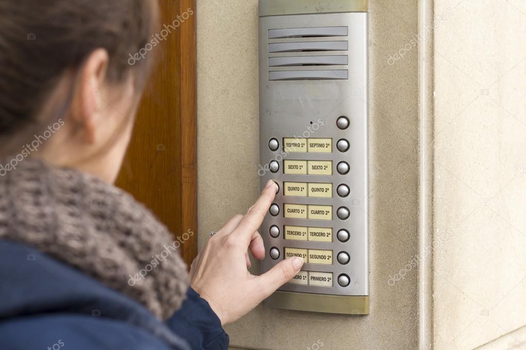 Woman  calling on the intercom and presses the button