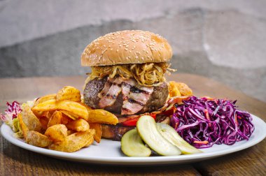 Hamburger domuz pastırması, kızarmış patates ve sebze ile