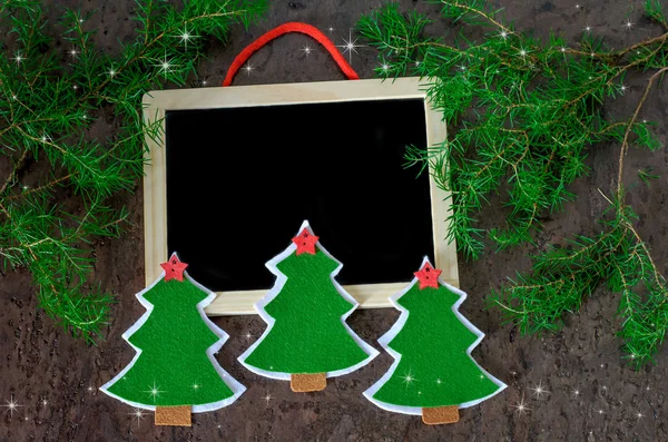 christmas decoration handed christmas trees from felt with red stars, shining stars and black chalkboard