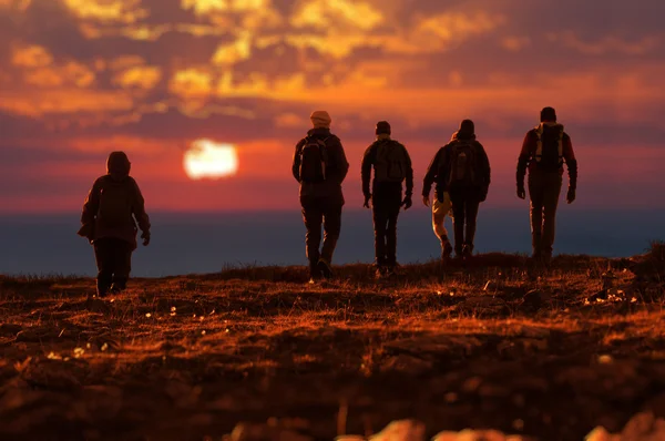 Six randonneurs marchant au coucher du soleil — Photo