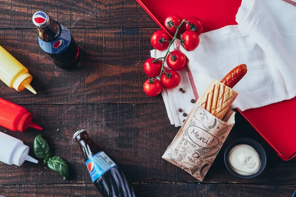 Hot dog med sennep, ketchup og mayonnaise på træbaggrund. Set fra oven - Stock-foto