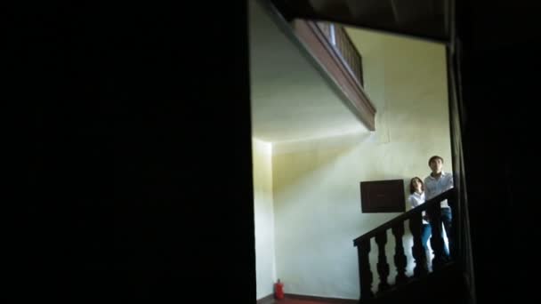 Young couple standing on stairs in house — Stock Video