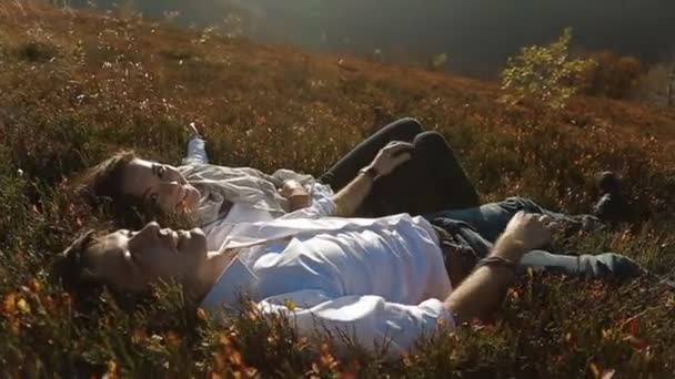 Пара, лежащая вместе на живописном лугу — стоковое видео