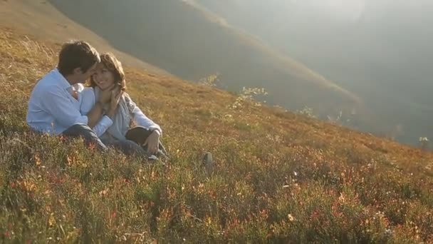 Couple en chemises blanches assis dans la prairie — Video
