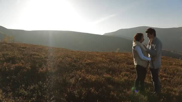 Couple in warm clothing embracing in meadow — Stock Video