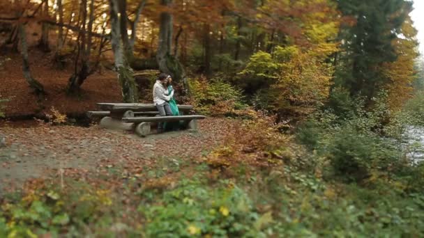 Paar in borduurwerk zittend op houten bankje — Stockvideo