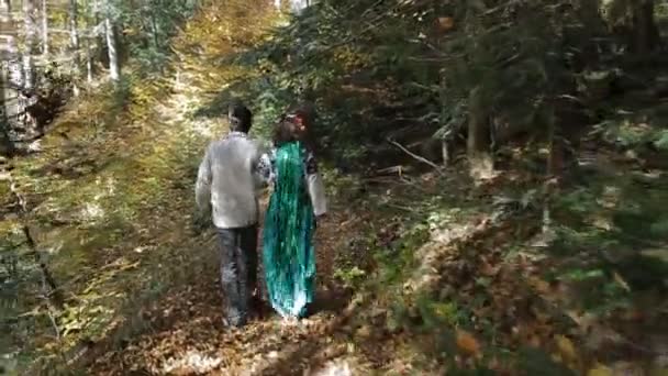 Couple in embroidery walking in green forest — Stock Video