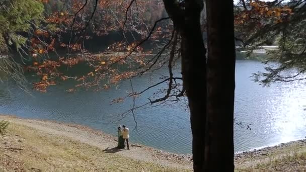 Casal em bordado em pé na margem do rio — Vídeo de Stock