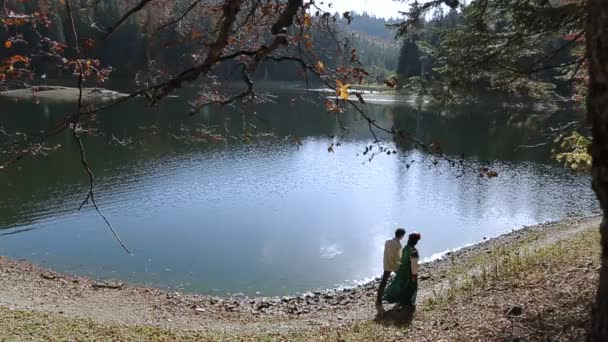 Пара у вишивці, що йде на березі річки — стокове відео