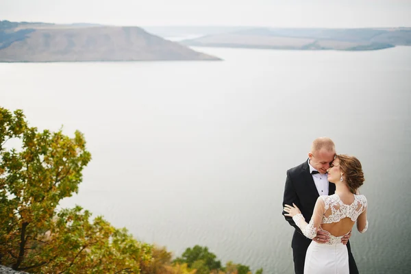 Amanti photoshoot in un abito da sposa in montagna vicino alla s — Foto Stock