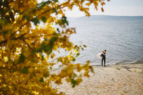 Коханці фотосесії в весільній сукні в горах біля с — стокове фото