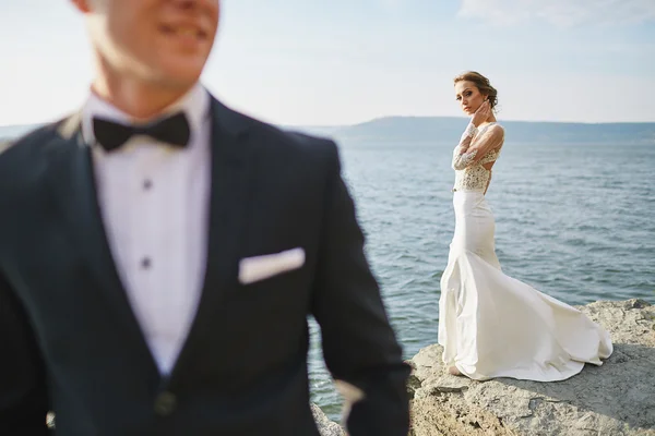 Влюбленных в свадебном платье отстреливают в горах у моря — стоковое фото
