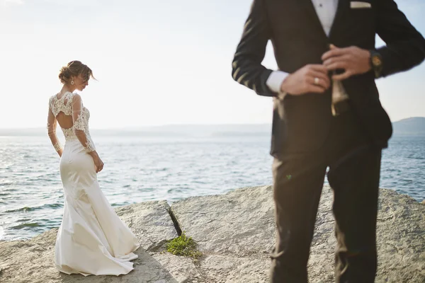 Fotocaça amantes em um vestido de noiva nas montanhas perto do s — Fotografia de Stock