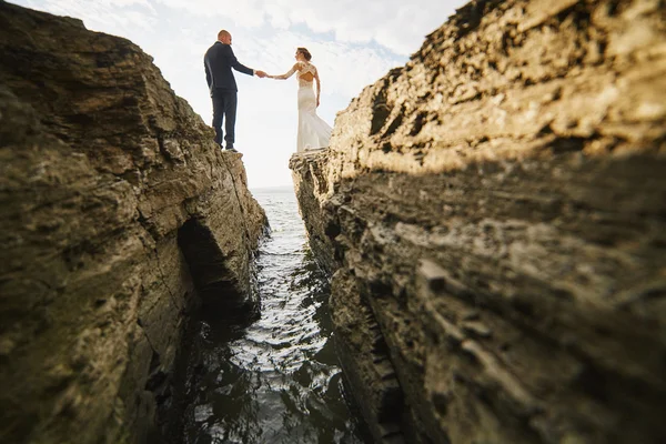 Fotocaça amantes em um vestido de noiva nas montanhas perto do s — Fotografia de Stock