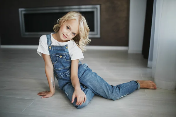 Молодая красивая девушка в джинсовой одежде в квартире — стоковое фото