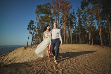 kumlu bir plaj üzerinde çalışan sadece evli çift