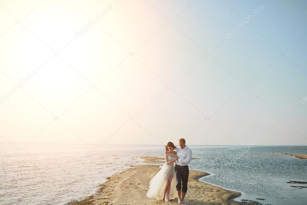 Just married couple running on a sandy beach