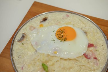 Kızarmış yumurtalı jambonlu risotto.