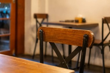 Kafenin ya da restoranın içinde, ahşap sandalyeli ve masalı.