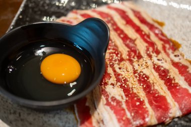 Dilimlenmiş göğüs eti, çiğ et ve bir kase çiğ yumurta. Pişirmeye hazır.