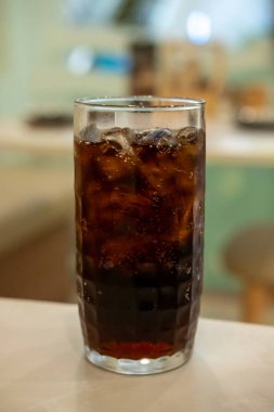 Masada bir bardak kola ve bokeh arkaplan.