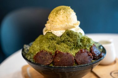 Yeşil çay bingsu, üstünde kırmızı fasulye ve dondurma, bir kase içinde servis edilir.
