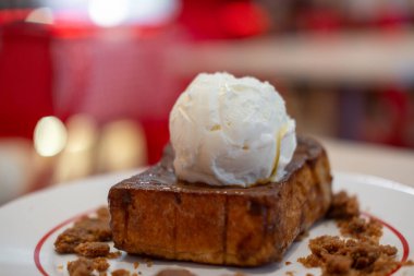 Tostun üstünde sütlü dondurma, tabakta servis edilir.