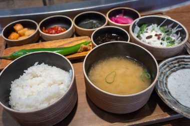 Bir kase pirinç ve çeşitli Kore mezeleri ile çorba..