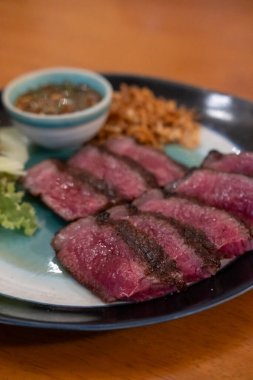 Orta pişmiş Picanha bifteği tabakta sebzeyle servis edilir.