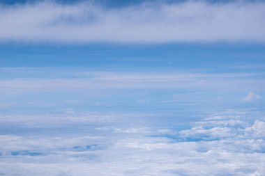 Gökyüzü ve bulutun gökyüzü manzarası uçağın penceresinden görülüyor