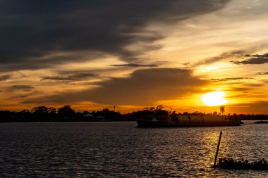 Nehir kenarındaki binanın siluetiyle gün batımı gökyüzü
