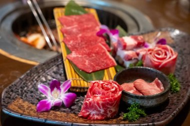 Çeşitli türde Japon stili dilimlenmiş nadir et tabakta, yumuşak odaklı.