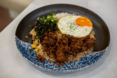 Kızarmış pirinçli sığır eti, dilimlenmiş et ve kızarmış yumurta.