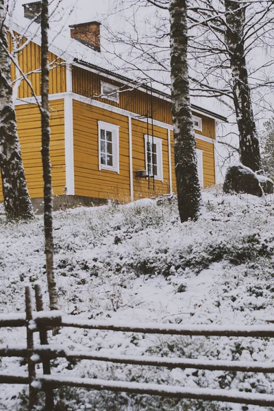 Gele landhuis onder de sneeuw — Stockfoto