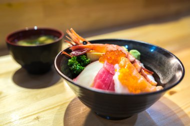 Chirashi suşi, Japon yemekleri, pilav kasesi Çiğ somon balığı, tarak, karides, surf clam, somon yumurta, ahtapot, ton balığı, hamachi ve miso çorbası ile servis tatlı çırpılmış yumurta ile Somon Yumurta alan etkili derinliği ile odak