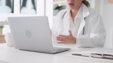 Asyalı kadın doktor bilgisayarlı bilgisayarla uzaktan kumandayla hastayla konuşuyor, reçete yazıyor. Tele sağlık, tele sağlık, hastane kliniği sağlık hizmetleri, veya internet teknolojisi konsepti