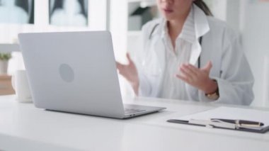 Asyalı kadın doktor bilgisayarlı bilgisayarla uzaktan kumandayla hastayla konuşuyor, reçete yazıyor. Tele sağlık, tele sağlık, hastane kliniği sağlık hizmetleri, veya internet teknolojisi konsepti