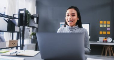 Laptop kullanan Asyalı genç bir iş kadını. Ev ofisinde online video görüşmesi. Evden çalışan kadın, uzaktan ağ ağı, internet teknolojisi, ya da sosyal uzaklık yaşam tarzı konsepti