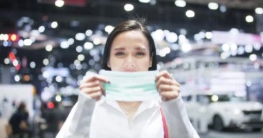 Mutlu Asyalı kadın gülümsüyor ve maske takıyor. Halka açık bir yerde kovid 19 enfeksiyonundan korunuyor. Temiz sağlıklı yaşam tarzı, açık hava güvenlik önlemi, koronavirüs önleme kavramı