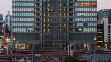 Asansörün zaman atlaması, insanların çalışması, iş merkezinin ön cephesine bakan ofis penceresi, tren ulaşımlı demiryolu. Şirket işi ya da şehir içi iş hayatı kavramı