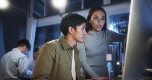 若いアジアのビジネスマンと女性は 自宅のオフィスでチームとデスクトップコンピュータで深夜一緒に仕事をしています プロジェクトブレインストーミングミーティング 小規模ビジネススタートアップ 同僚はチームワークの概念 — ストック動画